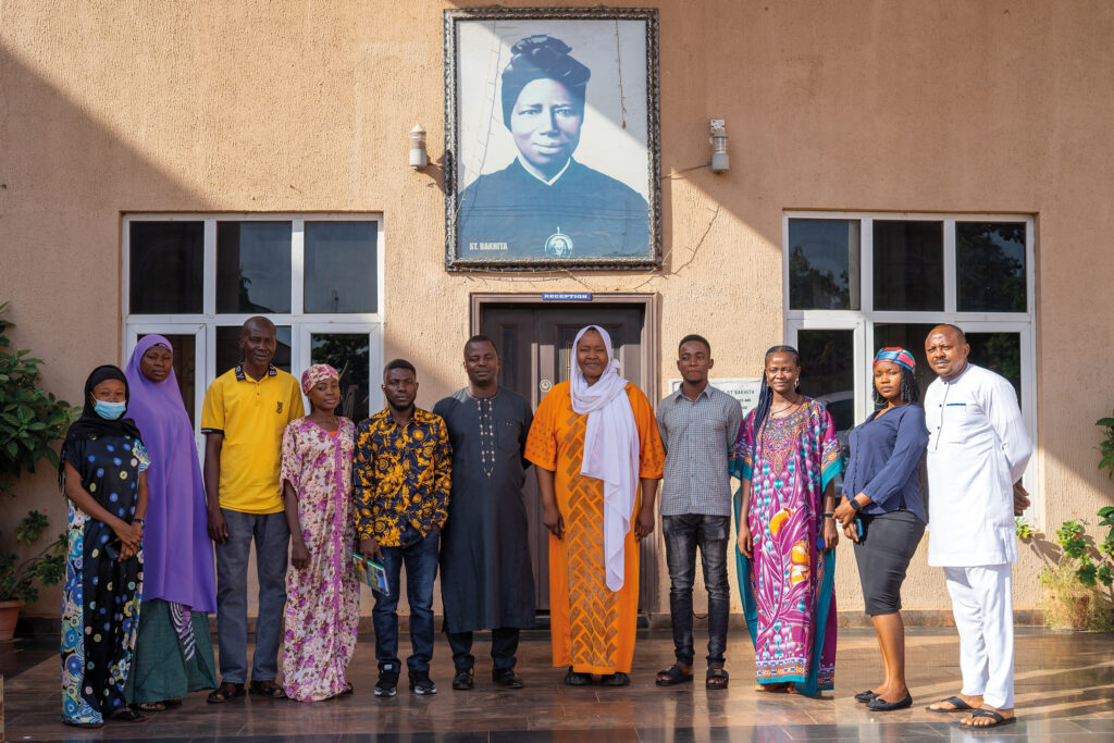 The employees of the Bakhita Initiative, a multi-ethnic team composed of Christians and Muslims, in front of the main façade of their headquarters in Sokoto.