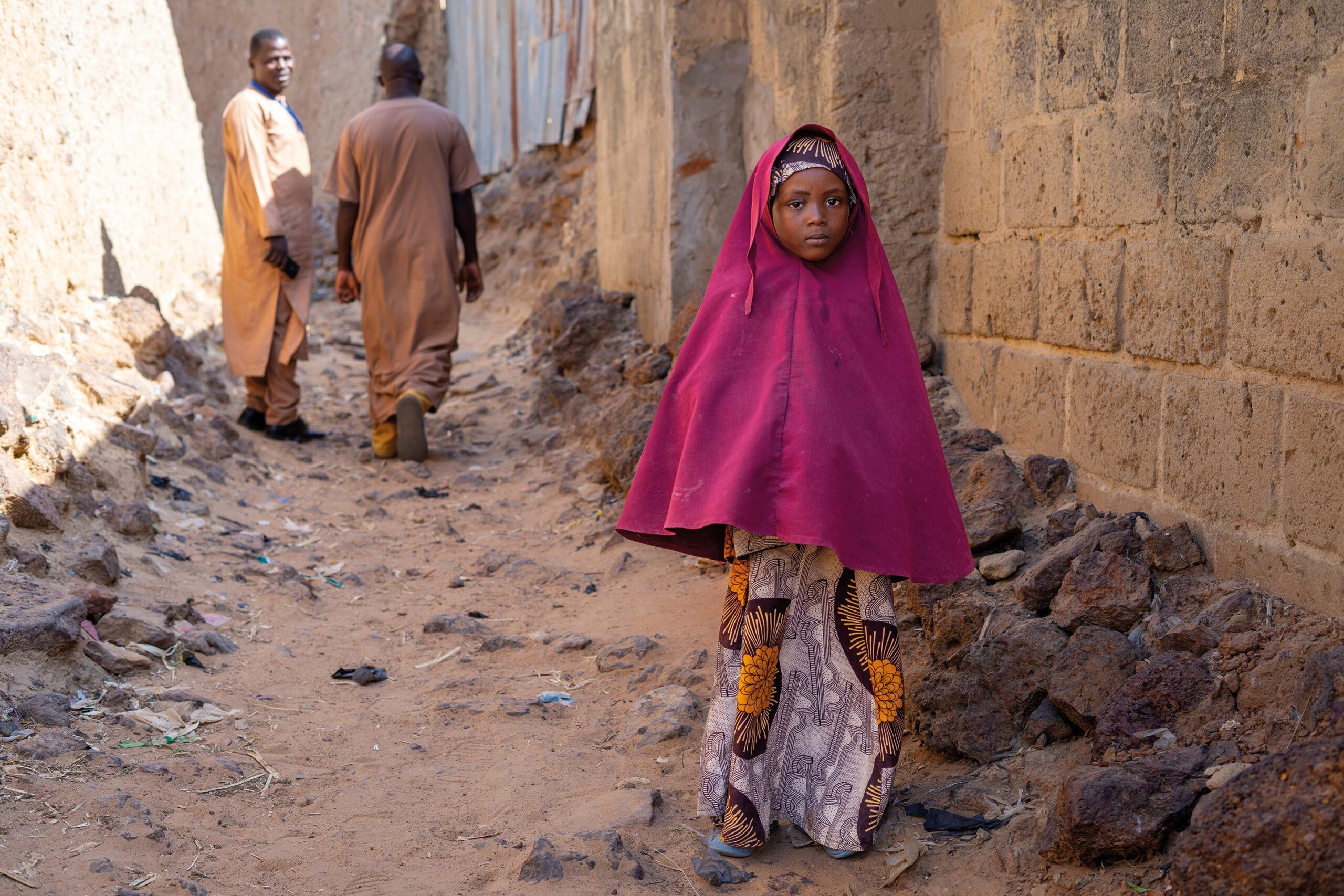 A girl in Wurno, north of Sokoto, an area where malnutrition is rife. In the background, two members of the Bakhita Initiative.