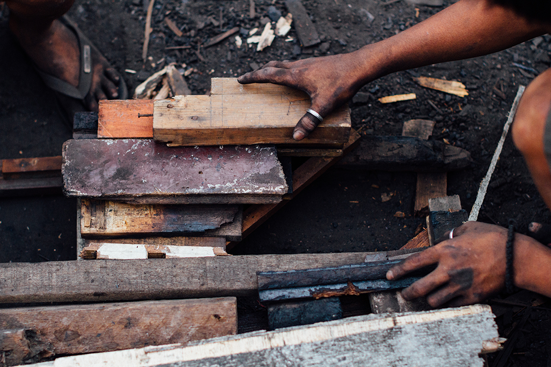 Boys making charcoal in the slum area of Ulingan, Tondo, Manila, Philippines, where entire families, including children and orphans, live and work.