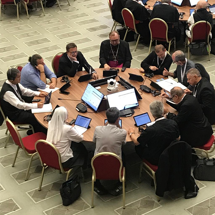 A group of delegates seated and engaged in discussions during the opening sessions of the Synod on Synodality, held in October 2023 at Vatican City.